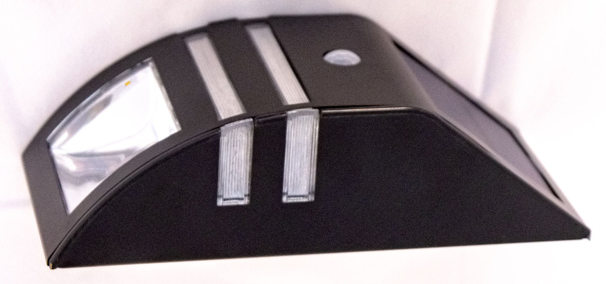 A black stainless steel step light with a built-in solar panel and motion sensor, designed for outdoor installation.