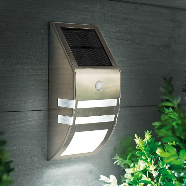 A stainless steel step light with a built-in solar panel and motion sensor, designed for outdoor installation.