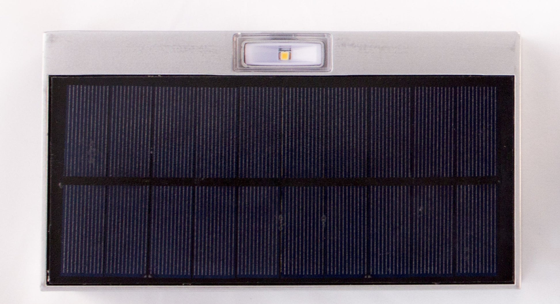 A rectangular silver LED up/down solar wall light with a solar panel on top and built-in LEDs.